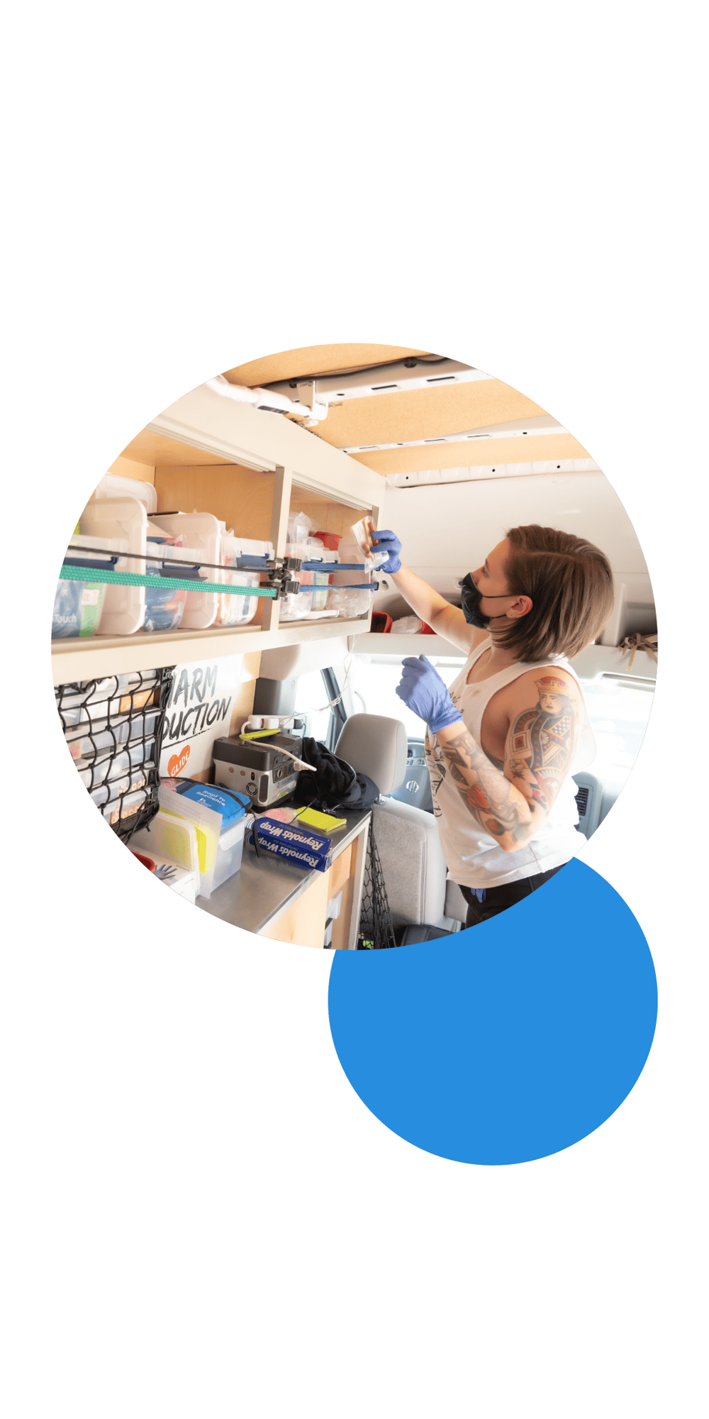 This is an image of a person looking at medical supplies inside of a medical vehicle. The person is wearing a mask, and blue medical gloves. The picture is placed inside of a circular frame. Behind the circle frame and placed slightly to the lower left is a medium blue circle.