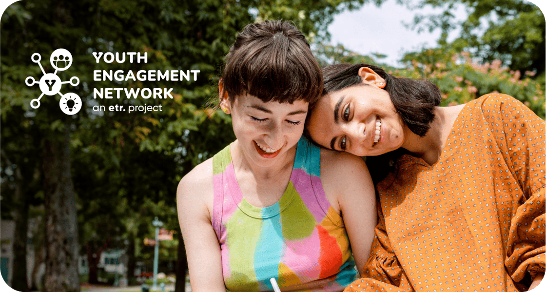 Two young people leaning on each other happily while outdoors next to the Youth Engagement Network (YEN) logo. 