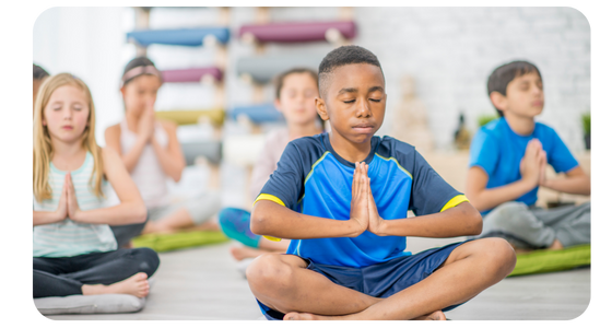 Image of young children all meditating in a class